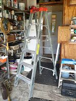 Full view of the Ridgid 6ft fiberglass step ladder standing upright in garage showing overall condition and use marks.