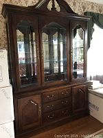 Full view of Thomasville hutch with dark wood finish, three glass doors above, and wooden cabinets and drawers below.