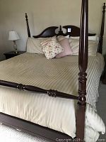 Side angle photo of the Thomasville four post king size bed showing carved headboard and turned posts.