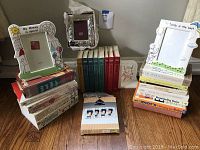 Photo showing three baby picture frames with text and a stack of assorted baby and parenting books.