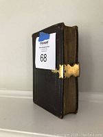 Side view of the vintage book showing the metal clasp and aged page edges.