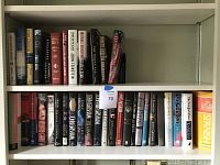 Two shelves filled with assorted books including fiction, non-fiction, and language learning titles.