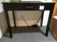 Front view of dark wooden sewing table with single drawer and silver handle. Table has four straight legs and measures approximately 34" L x 30" H x 20" W.
