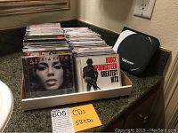 52 music CDs displayed standing vertically in a plastic tray showing front covers of albums by Alicia Keys and Bruce Springsteen