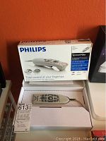 Photo of the Philips SpeechMike Classic microphone in original packaging, showing the microphone and box with brand and features.