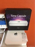 Apple Time Capsule device shown with original retail box in background, indicating model with 500GB storage and 802.11n Wi-Fi support.