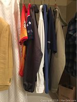 Hanging view of six sport clothing items including jerseys and jackets in various colors
