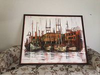Front view of the large framed oil painting showing boats at Fishermans Wharf with warm tones and reflections on water.