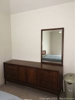 Front view of the wooden dresser with attached mirror showing six drawers and two doors.