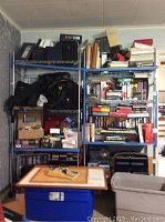 Front view of two metal shelving units filled with books, binders, boxes, and assorted office items.