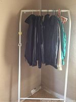 Rack of men's jackets hanging including leather and fabric with various colors and brands.