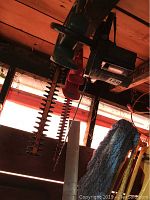 Two hedge trimmers and one chainsaw hanging from ceiling. Shows whole lot.