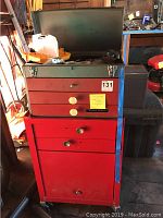Photo of the smaller red tool box with three drawers and open top showing tools inside.