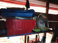 Photo showing Ryobi 40 gallon collapsible multi-purpose bag and Gladator 39 gallon reusable pop-up bag with tarps and red plastic bin