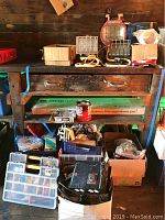 Wide shot showing shop light fixtures on wooden shelving with boxes of electrical supplies, wires, connectors, and miscellaneous