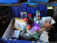 Plastic bin filled with assorted small plumbing supplies including fasteners, fittings, leak diverters, and copper joints.