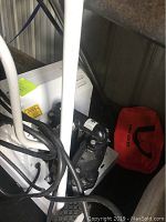 Close-up image showing white ARO pressure washer unit with attached black hoses and part of the metal frame.