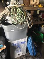 Marine rope coiled on top of plastic bin with Big Chief electric smoker below