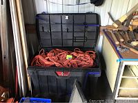 Pro Tuff Box open showing many orange extension cords inside.