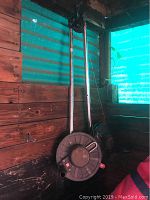 Two Scotty manual downriggers with metal arms and spool reels with line, mounted vertically on a wooden wall.