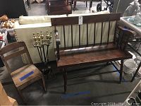 Wooden child's chair, dark wood bench and black metal fireplace tool stand with tools shown together