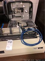 Photo showing Okidata U93 printer at front with blue cable, Pfaff 360 sewing machine in black carry case behind on table.