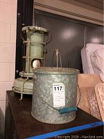Full view of both items on table - heater on left, bucket on right