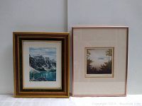 Two framed artworks side by side; left is a watercolor of a mountain lake scene, right is a framed print with a natural landscape.