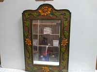 Full view of decorative wooden mirror with hand-painted flower and bee design on the frame