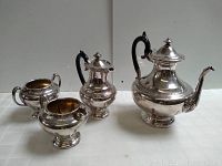Full view of the silverplated teapot, creamer, and sugar bowl arranged from tallest to shortest, showing the overall design and size.