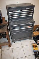 Two Stanley toolboxes stacked, seen from front with drawers closed, showing wear and caster wheels