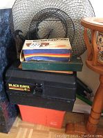 Stack of multiple fishing nets with collapsible metal frames and mesh nets, atop fishing tackle boxes including Black Hawk 6 model
