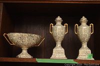 Three-piece vintage Empire bone china set consisting of two urn-shaped covered jars and one pedestal bowl with gold-toned handles and floral patterns.