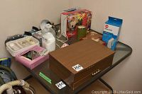 Overview of all items on glass table including therapy systems, humidifier, container with white powder, and flatware casket.