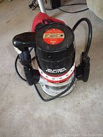 Top view of the black Sears Super Router with red and white model label, dust collection bag, and power cord visible.