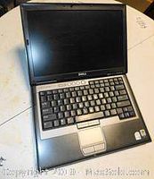 Front view of Dell laptop showing keyboard, screen, and touchpad with wrist rest area.