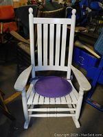 Full frontal view of the white Kennedy style rocking chair with purple cushion on the seat.