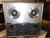 Front view of Sony reel-to-reel tape recorder showing tape reels, control panel with switches, knobs, and VU meters
