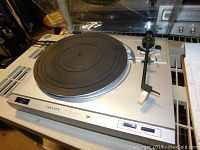 Silver SCOTT turntable featuring a manual tonearm, rubber platter mat, and control buttons. Shows general used condition.