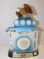 Front view of the vintage Jim Beam ceramic decanter with eagle figurine and Pearl Harbor commemorative design.