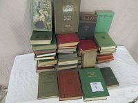 Overall group of 27 vintage hardcover books from the 1930s and 1940s stacked and standing, various colors and sizes visible.