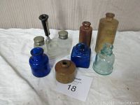 Full view of collection showing four stoneware and glass ink wells and bottles arranged on a cloth background