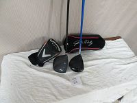 Two golf drivers side by side with respective headcovers