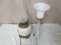 Photo of two antique electrified Wedgewood oil lamps side by side showing base, glass chimney, and trumpet glass shade