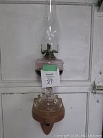Full view of the antique oil lamp mounted on the solid oak shelf with attached metal bracket, showing the overall height and glass chimney.