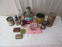 Full overview of the lot showing all items including tins, bottles, paper containers, and pink Kayee sewing machine.