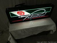 Fuji Film advertising sign illuminated on a table, showing full length with black frame and neon-like glowing design
