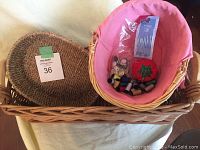Wicker baskets and sewing items arranged with visible pink cloth liner and assorted sewing notions inside basket