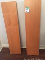 Two wooden rectangular shelves standing vertically, showing the smooth wood surface.