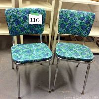 Pair of vintage chairs with blue-green floral vinyl upholstery and chrome legs, front and side view.